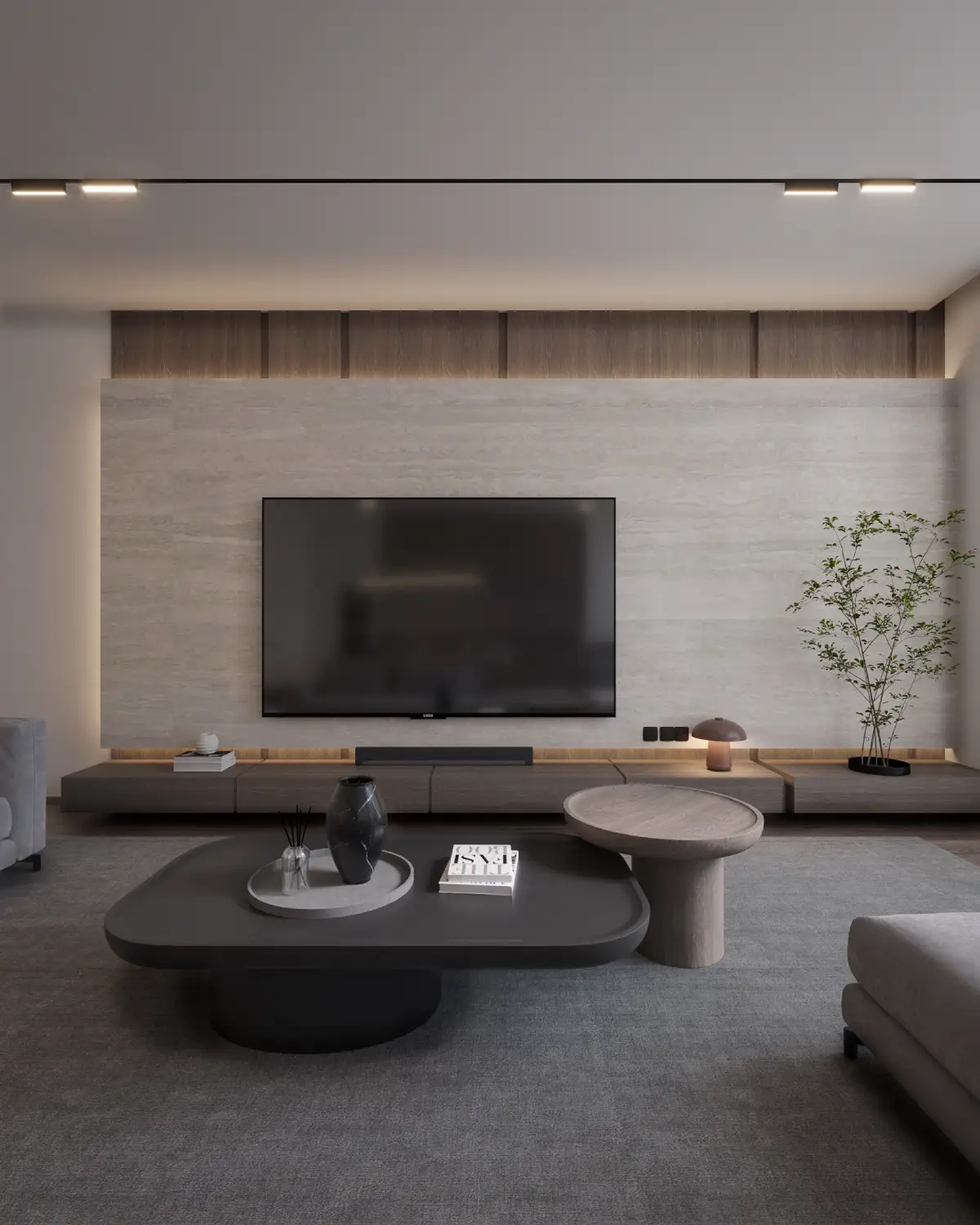 The Grid House living room with travertine wall render. Freeform organic-shape coffee tables on grey rug, sculptural side tables, integrated walnut media console, residential interior, Lahore.