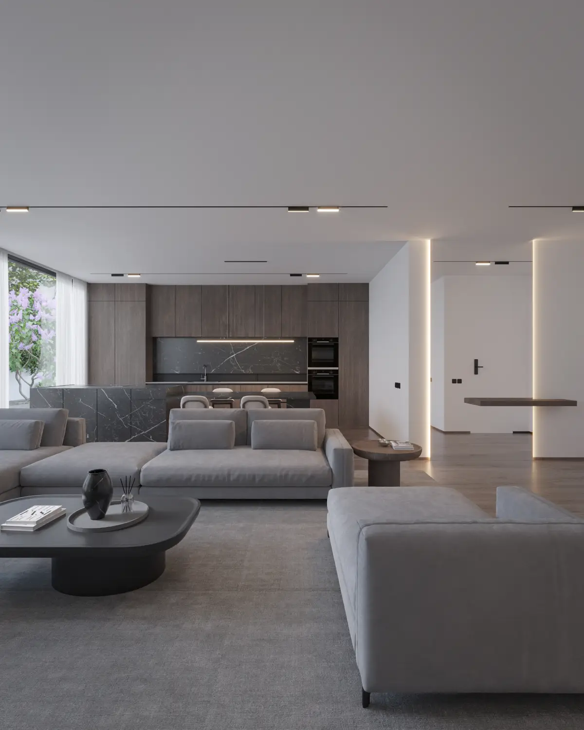 The Grid House open-plan living and kitchen render. Grey sectional sofas with sculptural black coffee table, black marble waterfall island and dark walnut kitchen beyond, residential interior, Lahore.