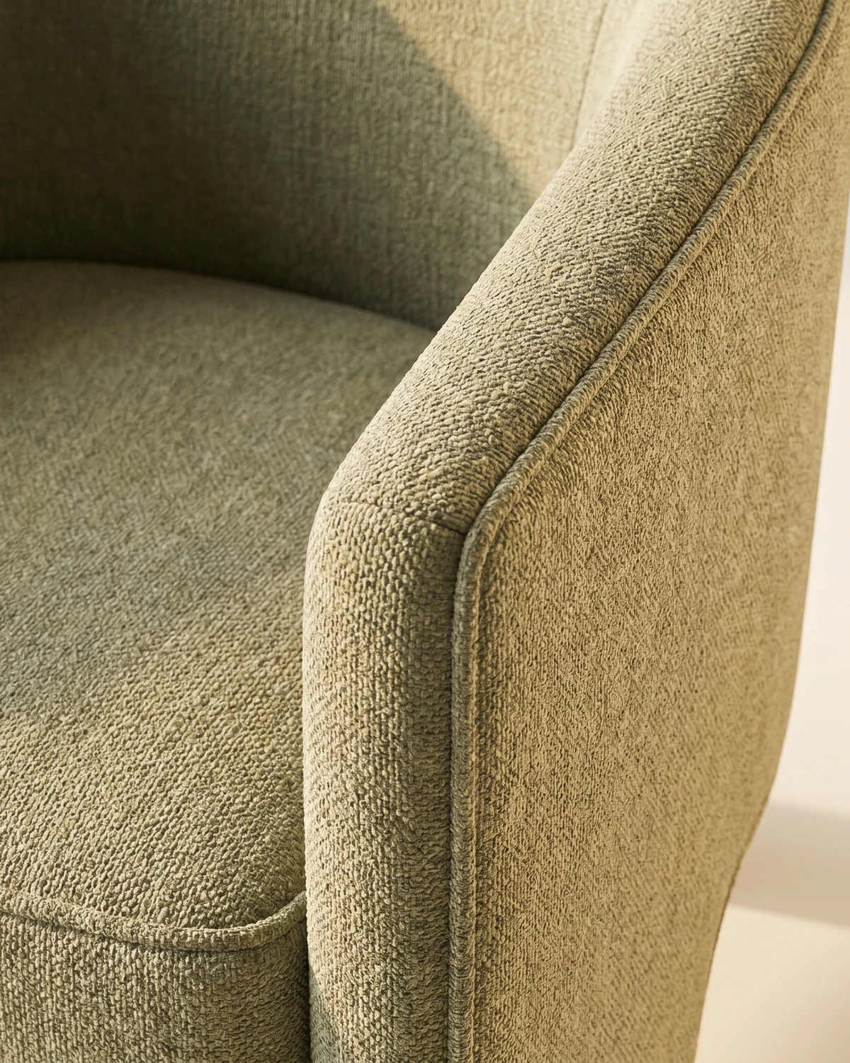 Quarry lounge chair detail, sage-green chenille weave on the curved barrel arm